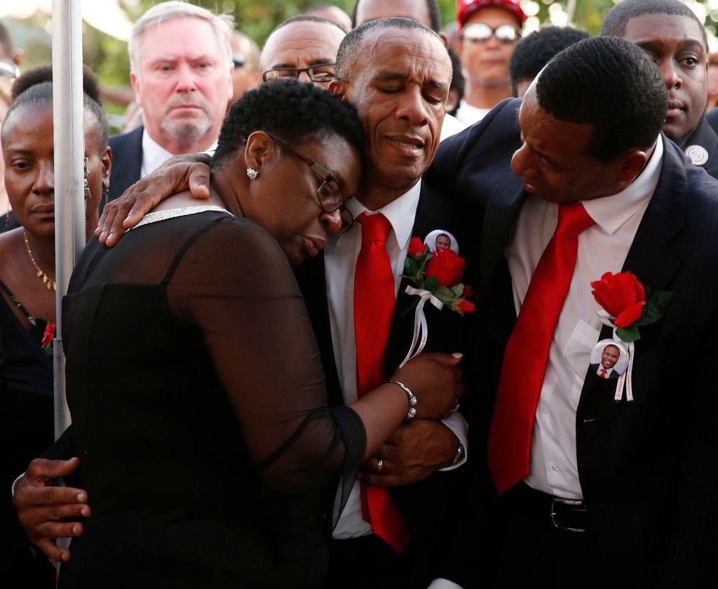 Allison and Bertrum Jean hug as they surrounded by family and friends as their son Botham...