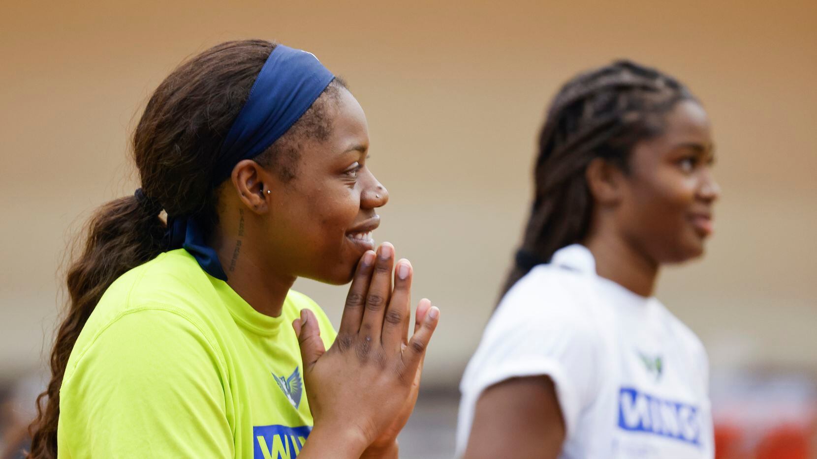Dallas Wings guard Arike Ogunbowale smiles as she listens to her teammates during a training...