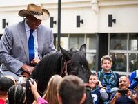 Charles Barkley arrives on horseback at the American Airlines Center as he makes his way to...