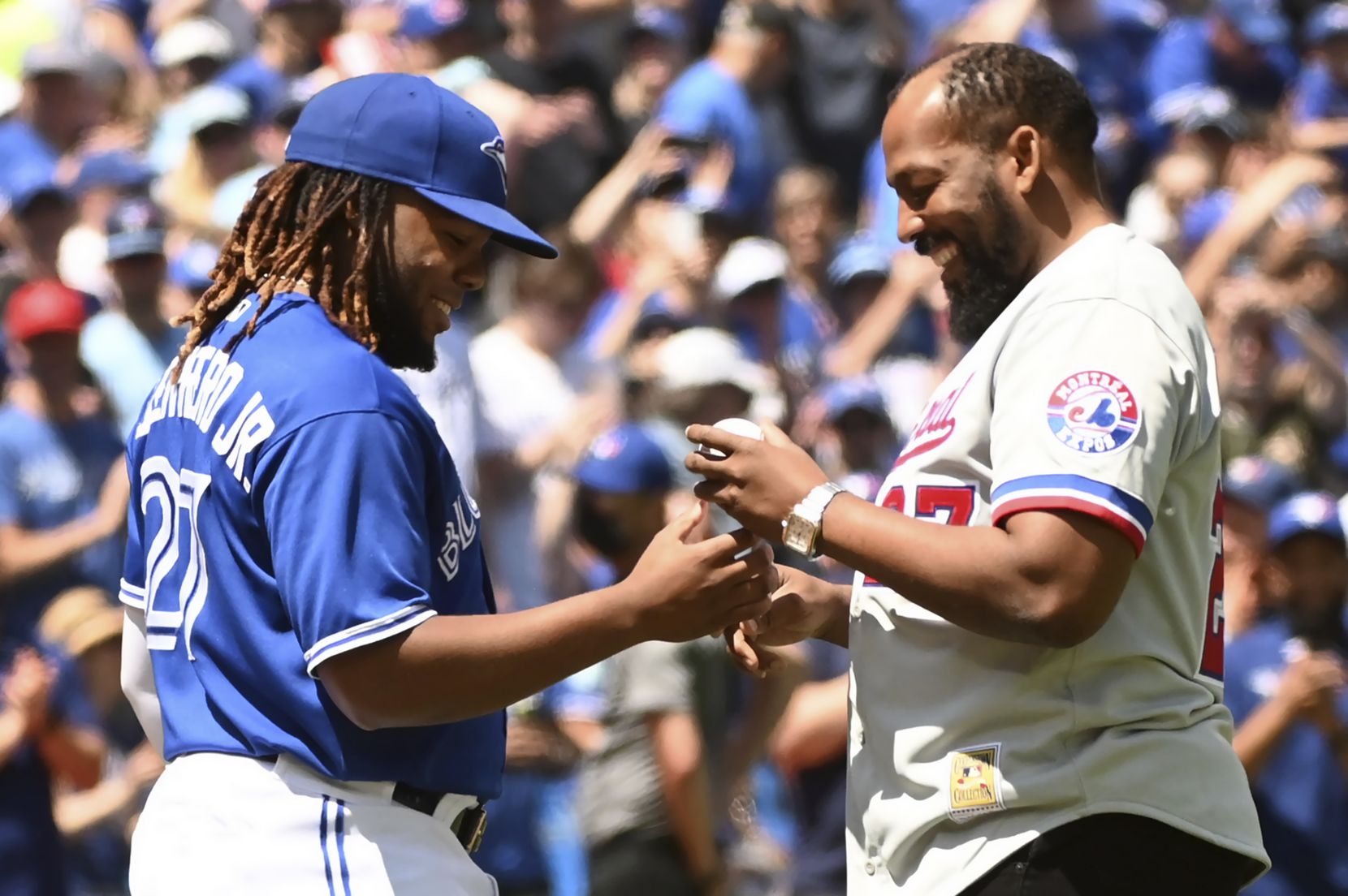 Toronto Blue Jays' Vladimir Guerrero, right, signs a baseball with his son, Vladimir...