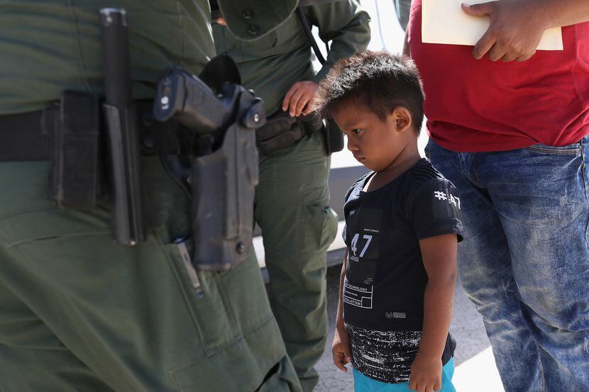 A boy and father from Honduras are taken into custody by U.S. Border Patrol agents near the...