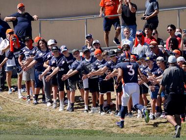 Denver Broncos quarterback Russell Wilson (3) slaps hands with fans as he runs onto the...