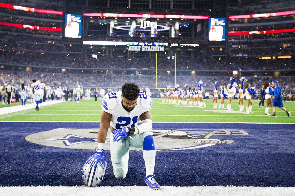 Dallas Cowboys running back Ezekiel Elliott kneels in prayer before an NFL football game...