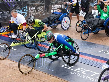 Wheelchair competitors cross the start line in front of Dallas City Hall as part of the BMW...