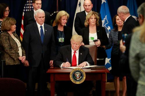 El presidente Donald Trump firma la acción ejecutiva que ordena la construcción del muro.
