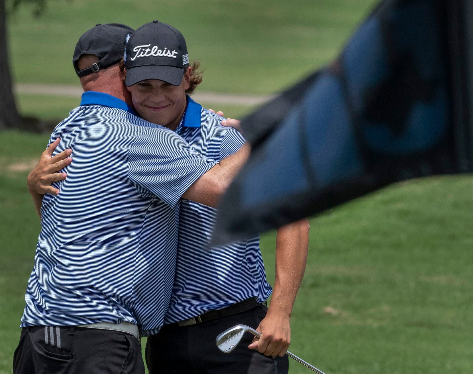 Plano West Matt Comegys gets a hug from his coach, Joe Cravens after chipping in on the 18th...