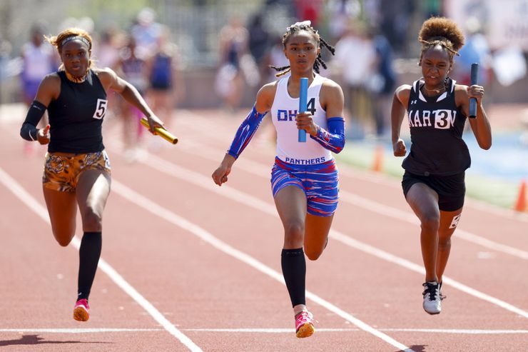 Duncanville’s Sanyah Keeton (center) runs to a win in the girls 4x100 meter relay ahead of...