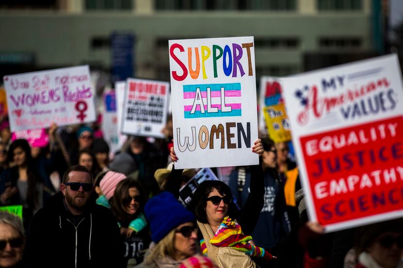 Demonstrators hold up signs during the Dallas Women's March on Sunday, January 20, 2019 in...
