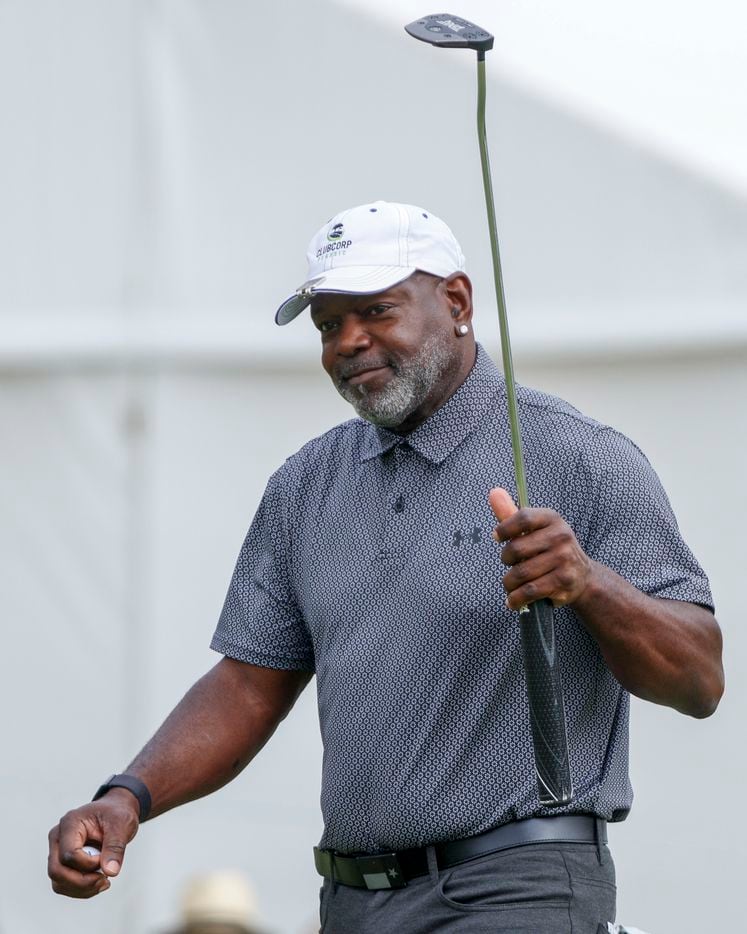 Former Dallas Cowboys player Emmitt Smith waves to the crowd after sinking a putt on the...