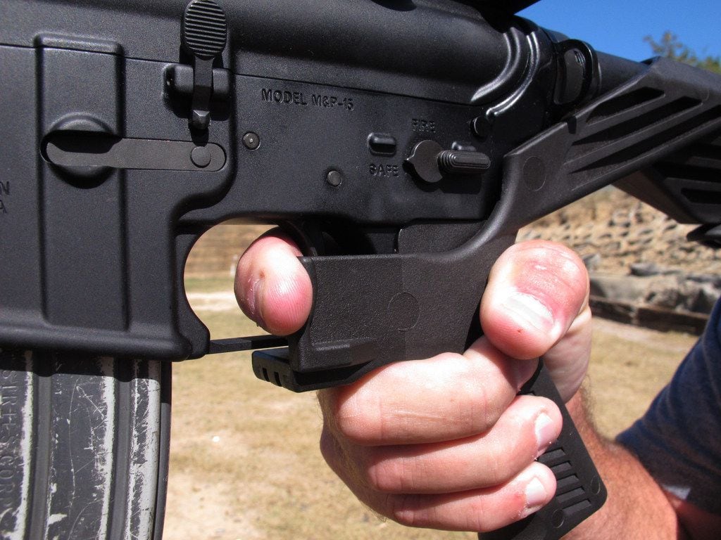 Shooting instructor Frankie McRae illustrates the grip on an AR-15 rifle fitted with a "bump...