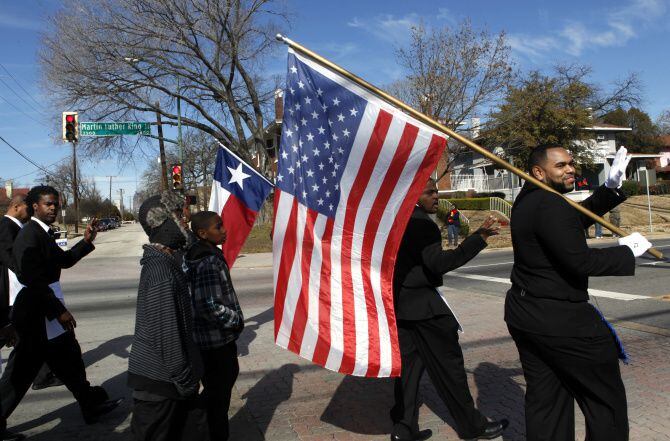 Members of the Jeremiah Grand Lodge carry the Texas and American flags as they marched down Martin Luther King Jr. Boulevard in Dallas on Aug. 27, 2019.