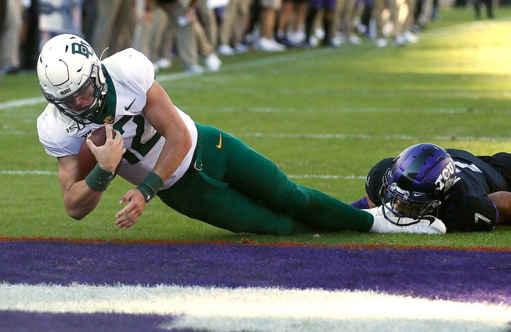 Baylor quarterback Charlie Brewer (12) dives across the goal line to score a touchdown as...