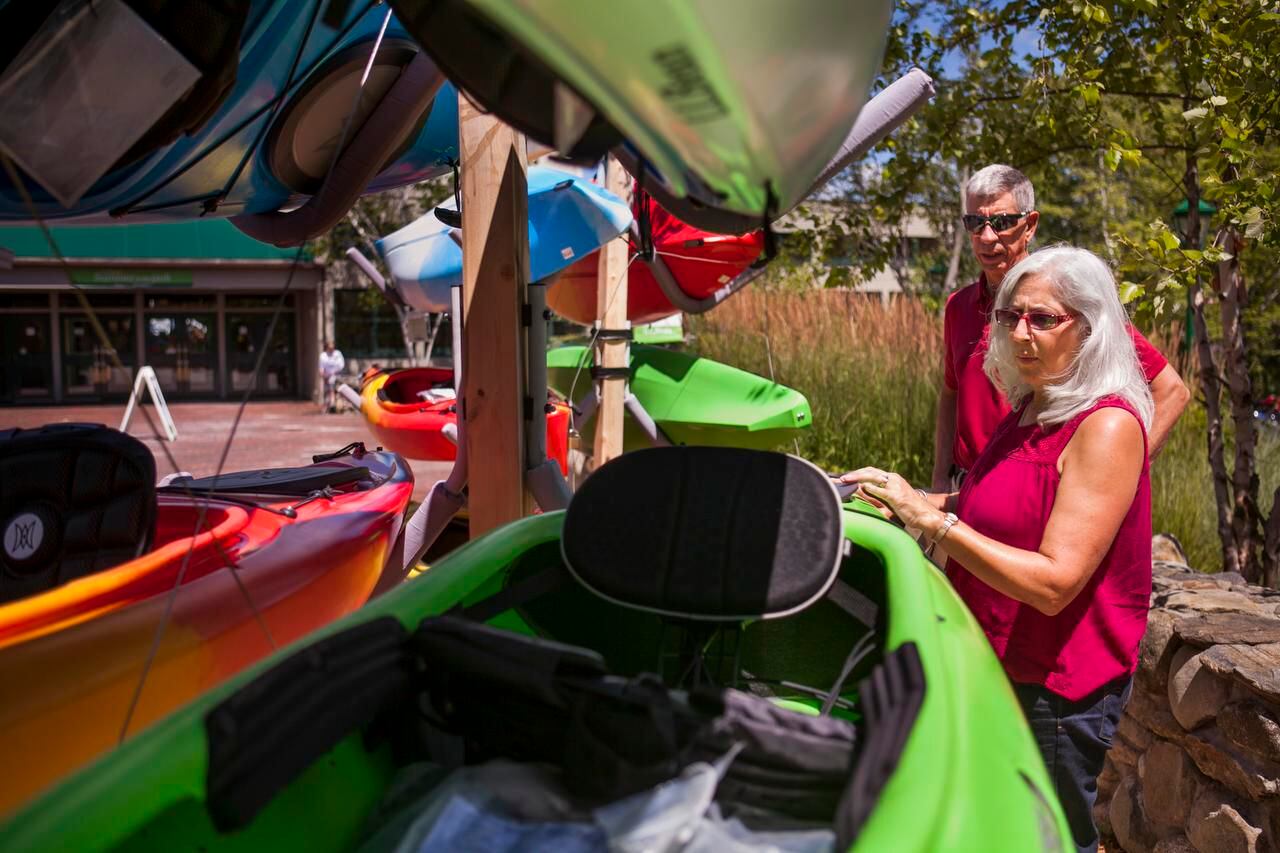 
Marie and John Koski admire some new kayaks at L.L. Bean while on vacation in Freeport, Maine. The Koskis are part of a growing group of vacationers 50 and older who are finding creative ways to travel economically.
