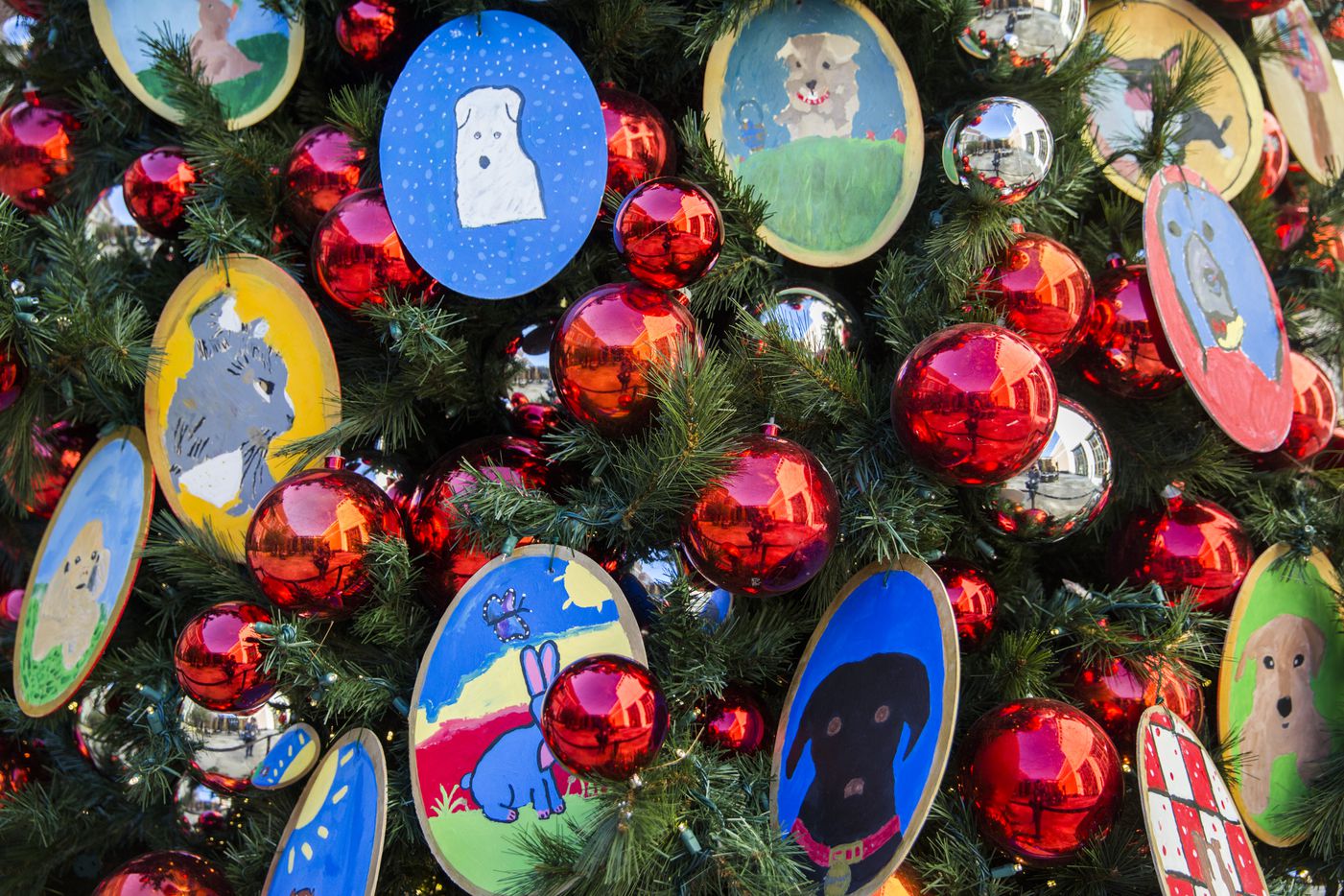 A Christmas tree decorated with ornaments made by elementary school children is displayed in...
