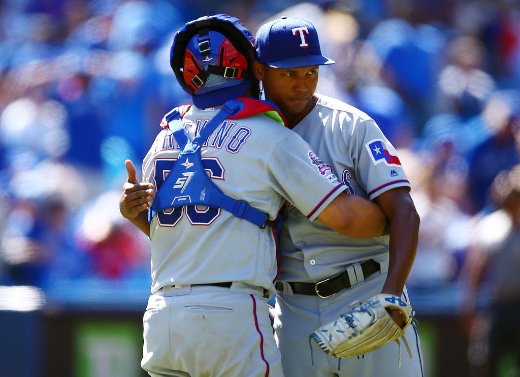 Texas Rangers catcher Jose Trevino embraces closer Jose Leclerc after wrapping up a 7-3 win...