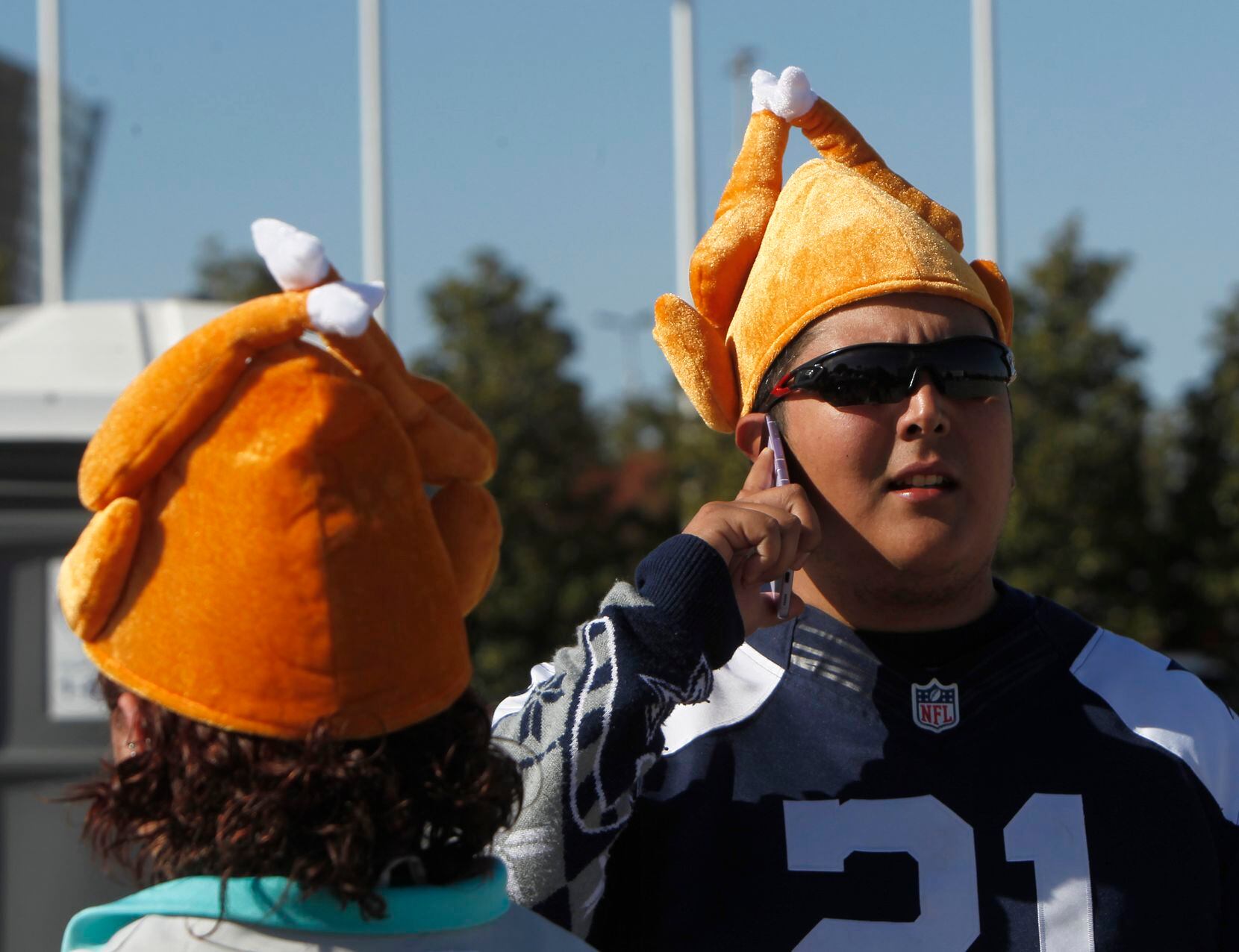 Cowboys fan Joshua Martinez sports a turkey hat as he gives driving directions to a friend looking for the tailgating lot hours before the opening kickoff. The two NFL teams played their Thanksgiving Day game at AT&T Stadium in Arlington on November 25, 2021. (Steve Hamm/ Special Contributor)