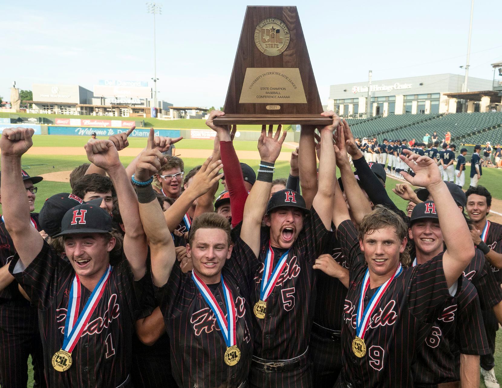 The Rockwall-Heath Hawks team celebrate with the championship trophy after defeating Keller...