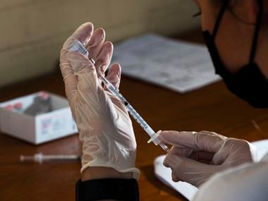 A medical professional prepares a Pfizer vaccine during a pop-up COVID-19 vaccine clinic operated by Dallas County Health and Human Services outside of the Garibaldi Bazaar along East RL Thornton Freeway in Dallas, on Sept. 25, 2021.