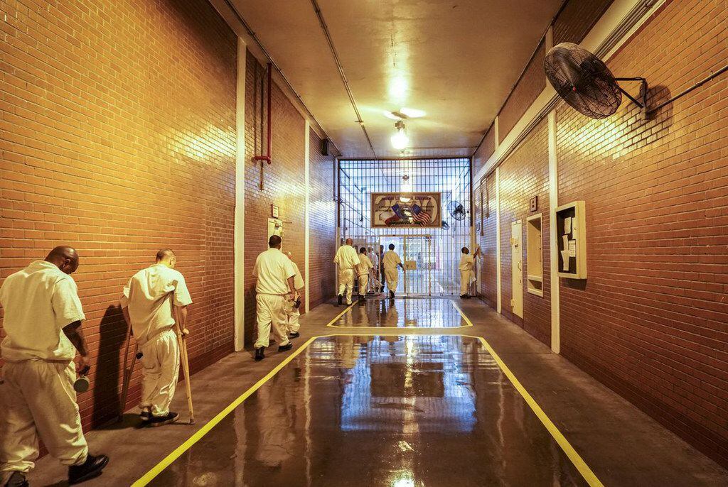 Inmates shuffle past new fans in the former Darrington Unit's main hallway on a hot July day.