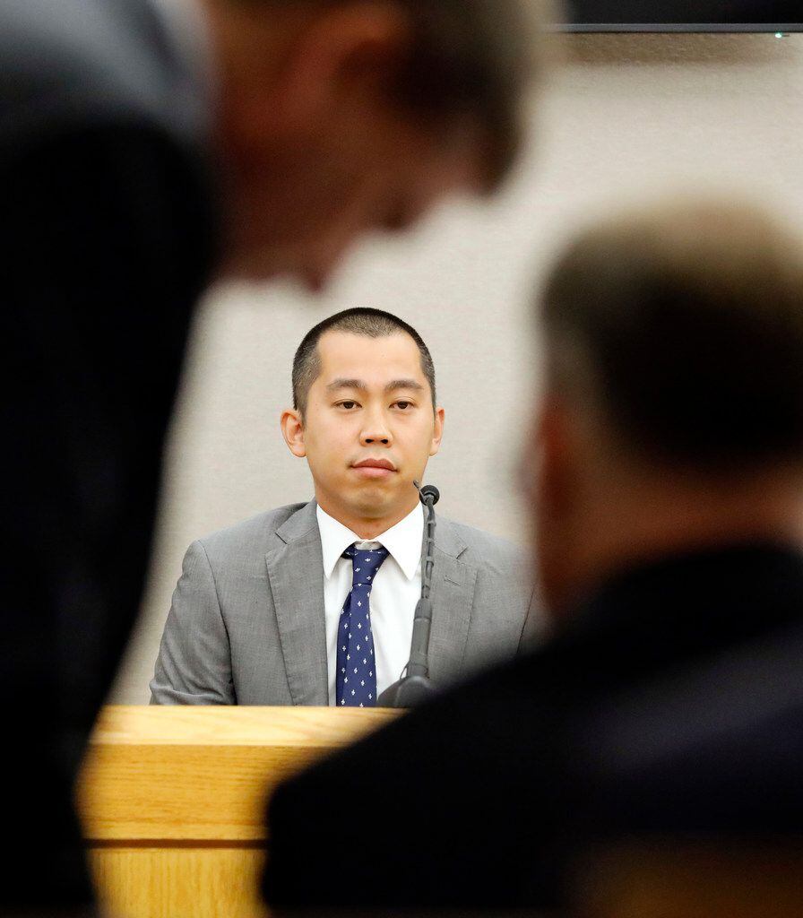 Police Officer Tu Nguyen waits as defense attorney Toby Shook (left) and Assistant District Attorney Jason Hermus (right) discuss evidence photos during the murder trial of Amber Guyger on Thursday.
