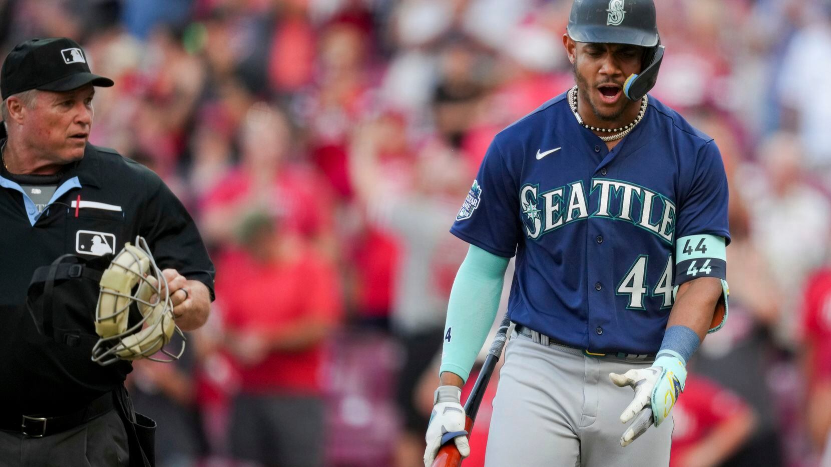 Seattle Mariners' Julio Rodriguez, right, reacts to umpire Marvin Hudson, left, after...