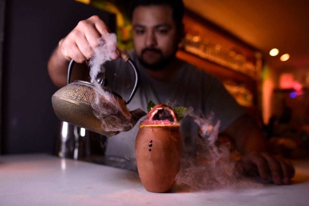 La Viuda Negra owner Javier Villalva pours mezcal cooled by dry ice for the Adela cocktail...