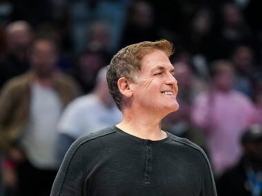 Dallas Mavericks owner Mark Cuban smiles as he stands on the court during a timeout in the...
