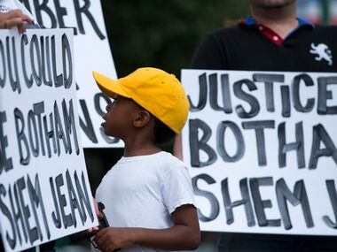 "Young King" Solomon Grayson, 6, looks over at a sign that reads "You Could be Botham Shem...