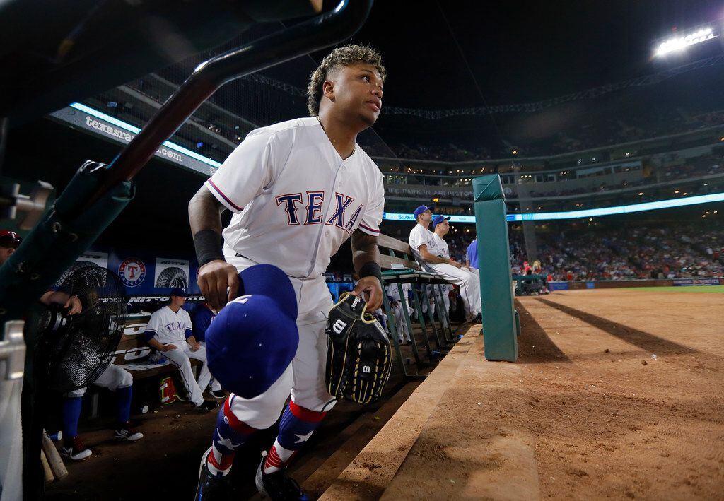 Texas Rangers left fielder Willie Calhoun heads out of the dugout for the fourth inning of...