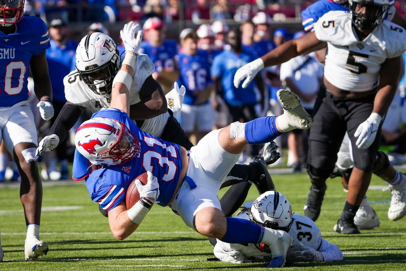 SMU running back Tyler Lavine (31) is knocked off his feet by UCF defensive back Quadric...
