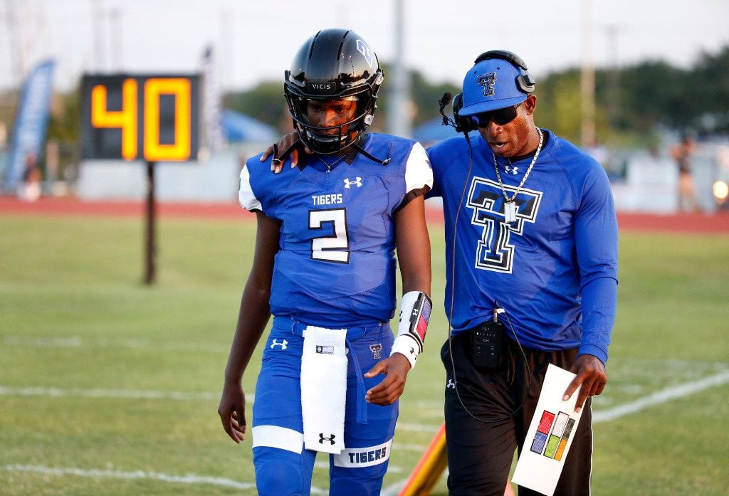 Trinity Christian-Cedar Hill offensive coordinator Deion Sanders (right) talks to his son, Shedeur Sanders, before a game in 2017. (Michael Ainsworth/Special Contributor)

