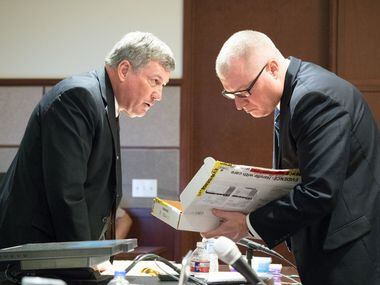 Assistant district attorney Tony Paul presents the gun as evidence to Eric Johnson's...