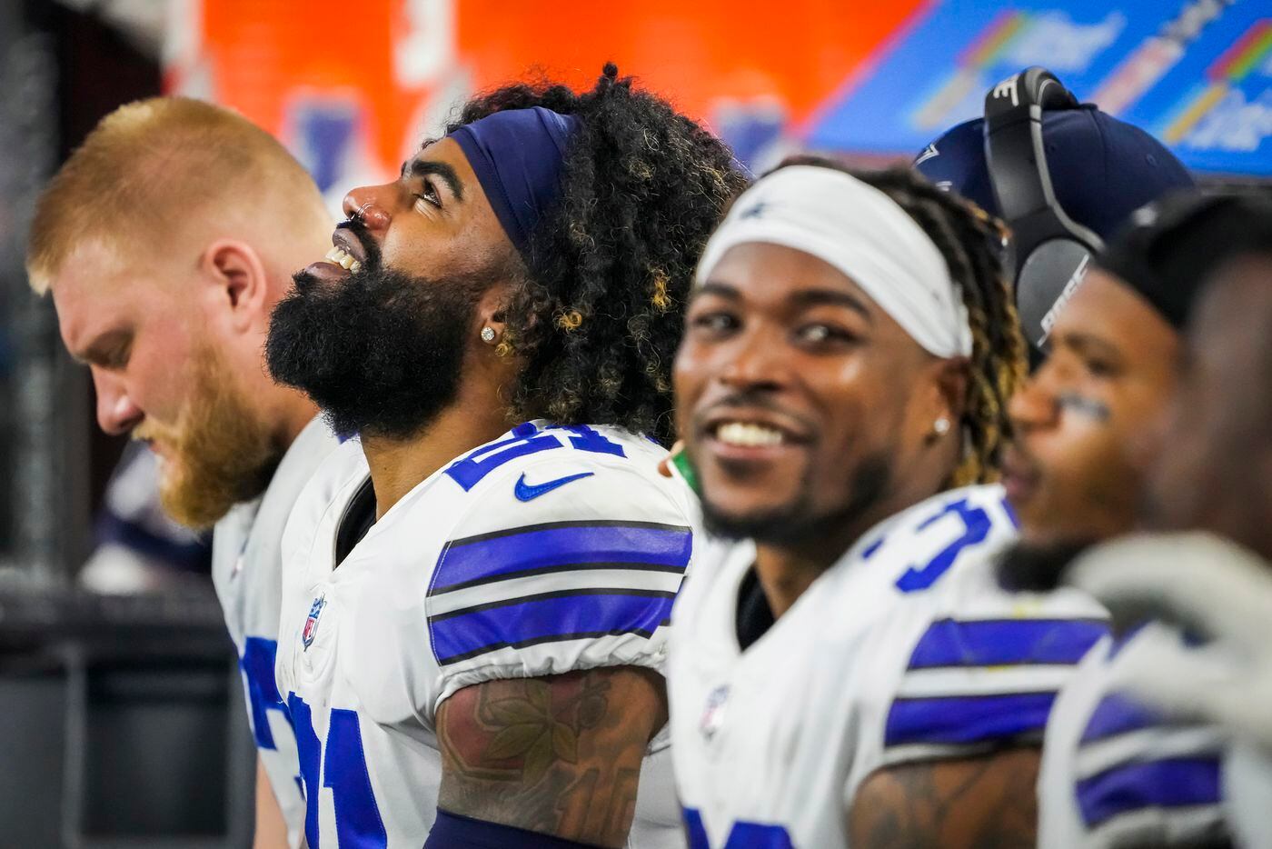 Dallas Cowboys running back Ezekiel Elliott (21) looks up at the scoreboard as he watches from the bench during the second half of an NFL football game against the Washington Football Team at AT&T Stadium on Sunday, Dec. 26, 2021, in Arlington. The Cowboys won the game 56-14.