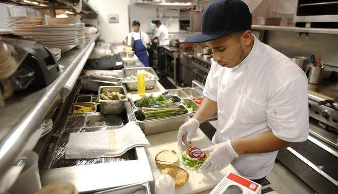 Cris Ayala, un estudiante de El Centro College que aspira a ser chef, trabaja en la cocina...