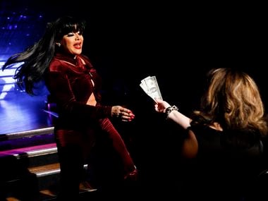 Sasha Andrews reaches for a tip while performing as Selena during the Legendary Rose Room...
