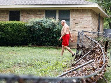 Home owner, Garry McDaniel walks by the damaged fence of his house in Balch Springs, a day...