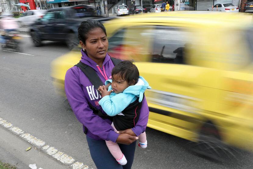 Jenifer Salas, de 27 años y originaria de Venezuela, carga a su bebé mientras pide ayuda en...