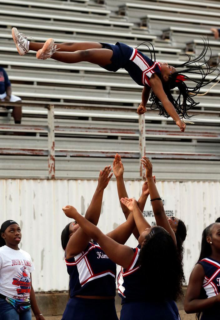 The Kimball cheerleaders throw a flyer high into the air before the start of the first half...