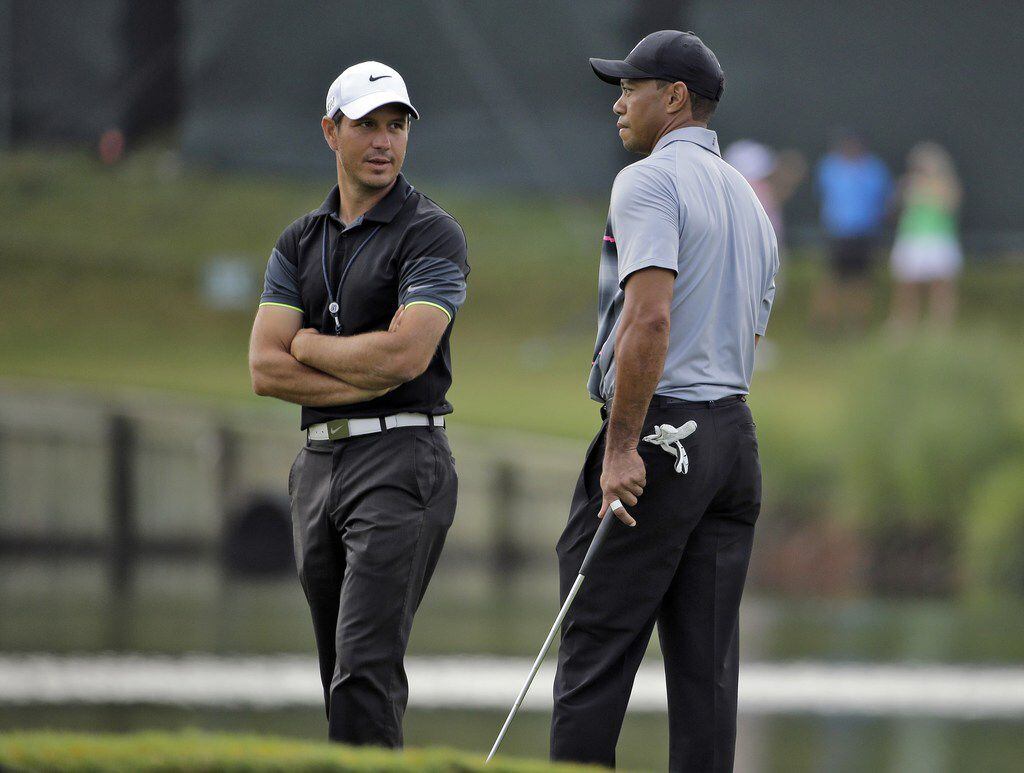 FILE - In this May 6, 2015, file photo, Tiger Woods, right, talks with swing coach Chris...