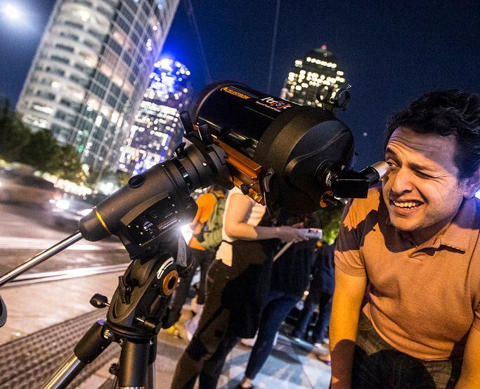 Alan Robles looks at the moon through a telescope during the Otsukimi Moon Viewing at Klyde...