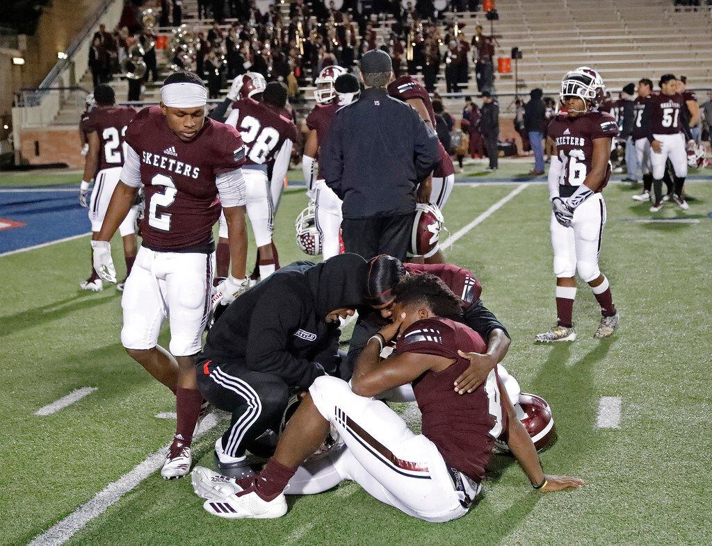Mesquite High School running back Ladarius Turner (4) is comforted by team mates after being...