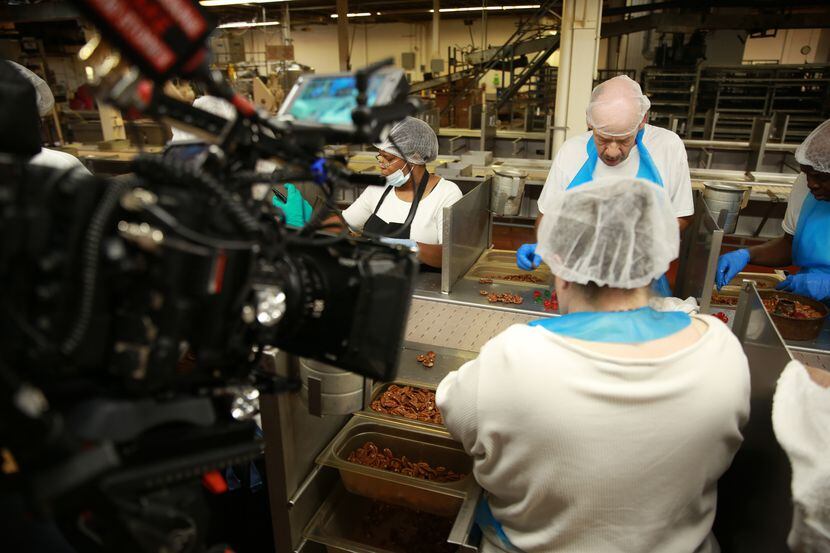 A documentary crew films workers making fruitcake at Collin Street Bakery.
Bakery workers.