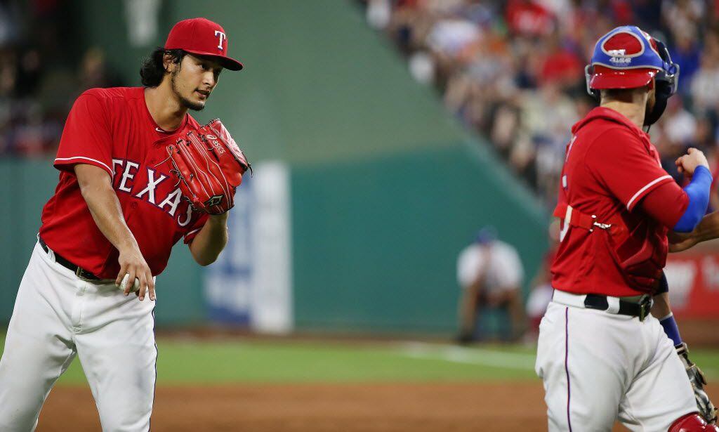 Texas Rangers starting pitcher Yu Darvish (11) speaks with catcher Jonathan Lucroy (25)...