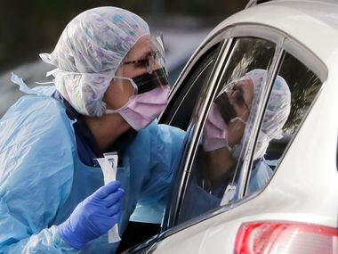 La enfermera registrada Laurie Kuypers toma una muestra nasofaringea para una prueba de...