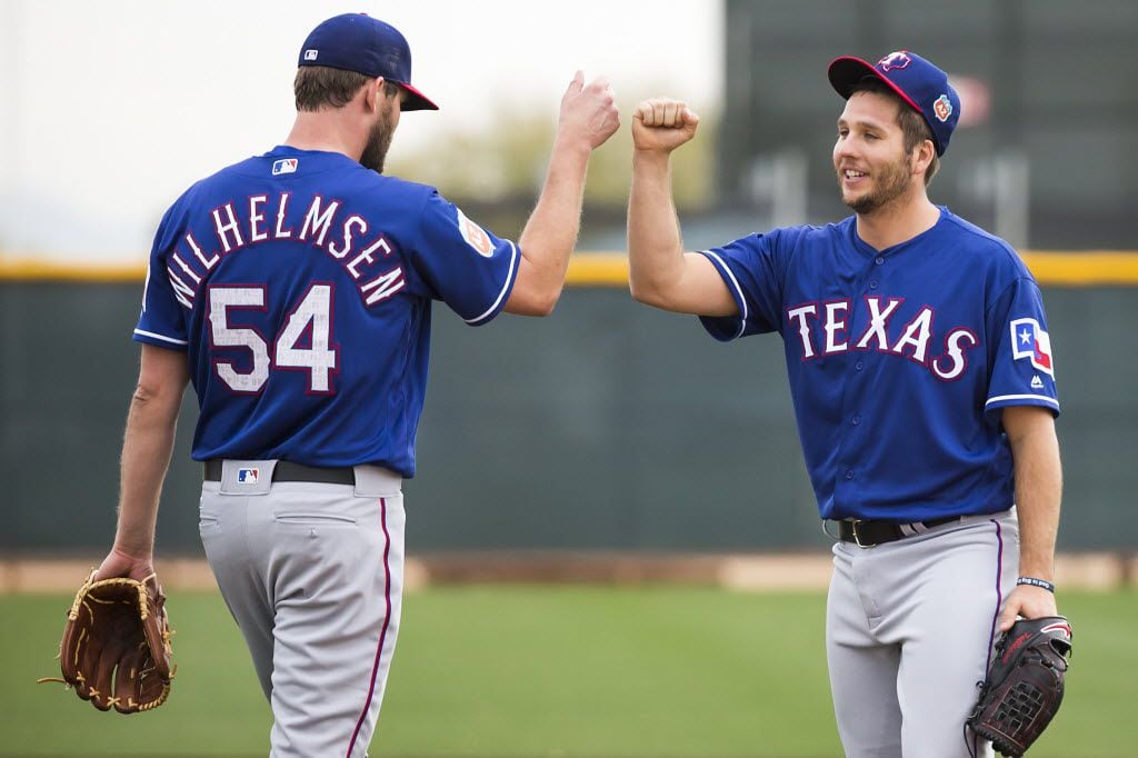 Texas Rangers pitcher Shawn Tolleson first bumps pitcher Tom Wilhelmsen during a fielding...