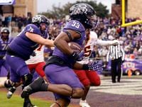 TCU Horned Frogs running back Kendre Miller (33) carries the ball in for a late second...