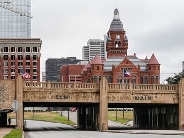 A jogger (far left) passes by Martyrs Park (left) on Thursday, Jan. 23, 2020 in Dallas. At right is the Triple Underpass, and behind it is Dealey Plaza.