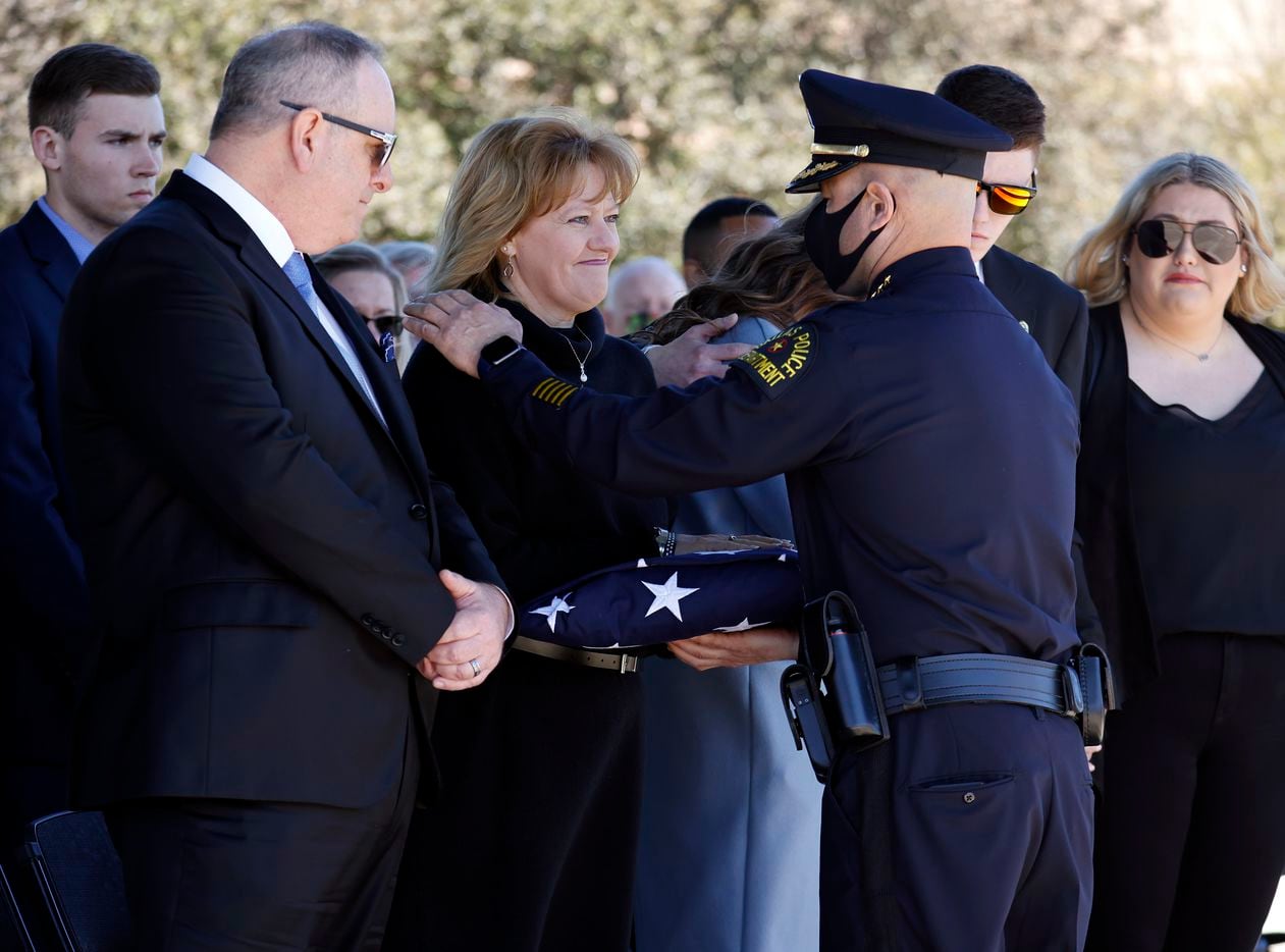 Dallas Police Chief Eddie Garcia (right) hands Kathy Penton (center), mother of Dallas Police officer Mitchell Penton, a folded U.S. flag following a funeral service for her son at Prestonwood Baptist Church in Plano, Texas, Monday, February 22, 2021. Penton was killed, Saturday, Feb. 13, 2021, in a crash involving a drunk driving suspect. (Tom Fox/The Dallas Morning News)
