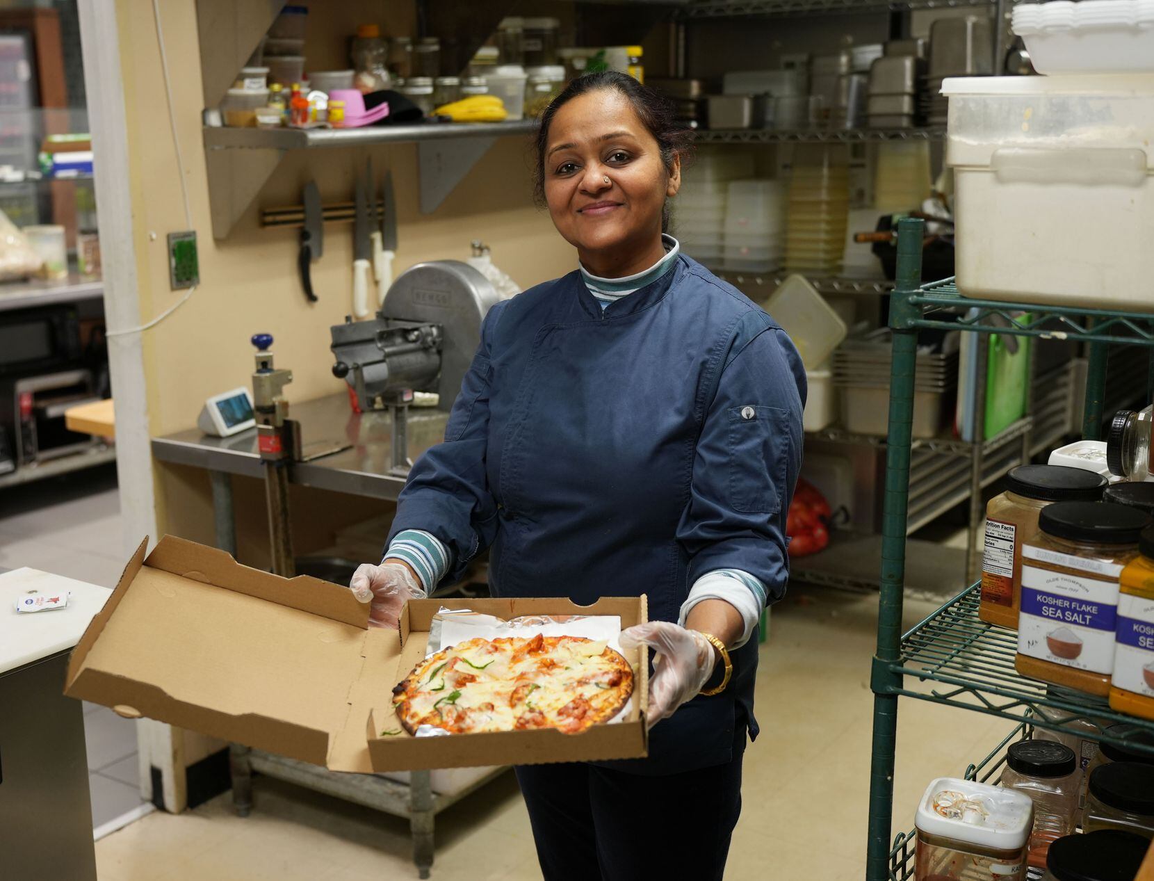 Chef Nidhi Mittal with her popular Butter Chicken Pizza at Far East Pizza Co. in Richardson. 