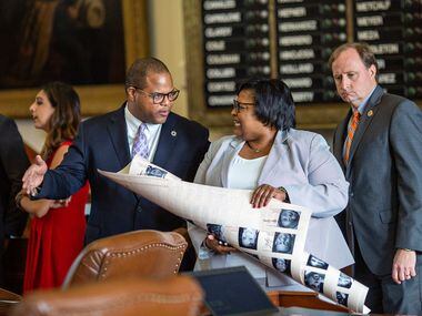 State Rep. Eric Johnson (left) chats with State Rep. Toni Rose on the House floor just...